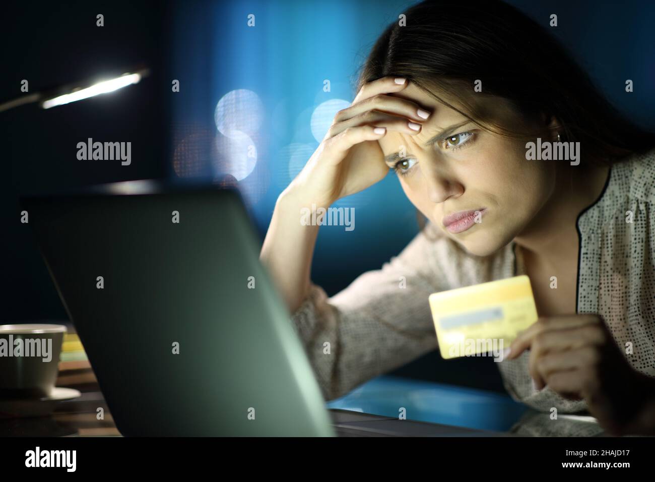 Besorgt Frau in der Nacht kaufen online mit Kreditkarte und Laptop zu Hause Stockfoto