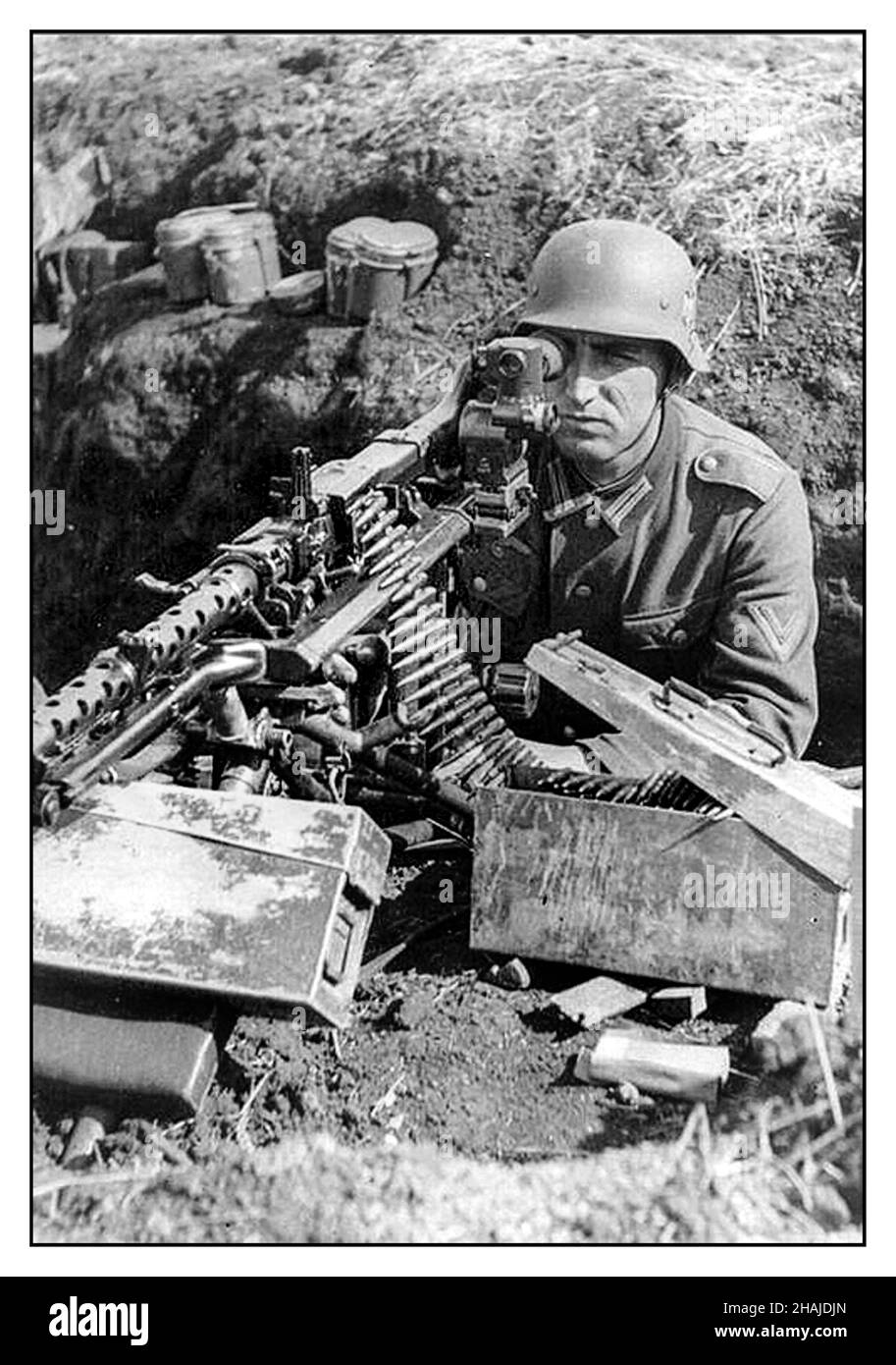Nazi MG-42 Maschinengewehr WW2 Propaganda Image Wehrmachtsarmee Nazi-Soldat im Grabenauszug mit MG-42 Maschinengewehr mit optischer Sicht, Munitionsboxen in der Nähe Stockfoto