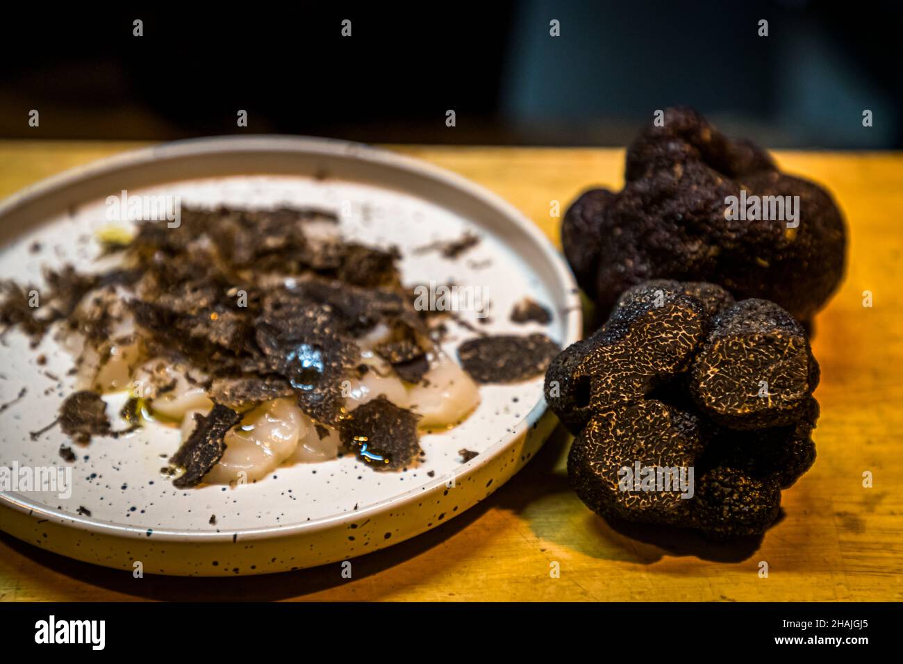 Frische Jakobsmuscheln mit Meersalz, schwarzem Pfeffer und Olivenöl und frisch rasierten schwarzen Trüffeln. Reduziert auf diese wenigen Zutaten, kommt der Geschmack des schwarzen Trüffels sehr gut zum Vorliegen. Aups, Frankreich Stockfoto