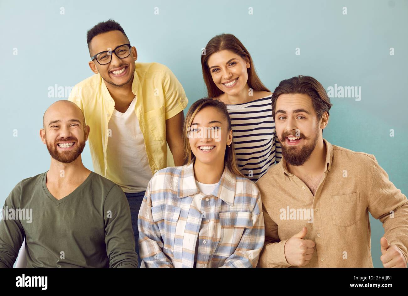 Gruppenportrait von fröhlichen jungen multiethnischen Freunden, die vor der Kamera lächeln Stockfoto