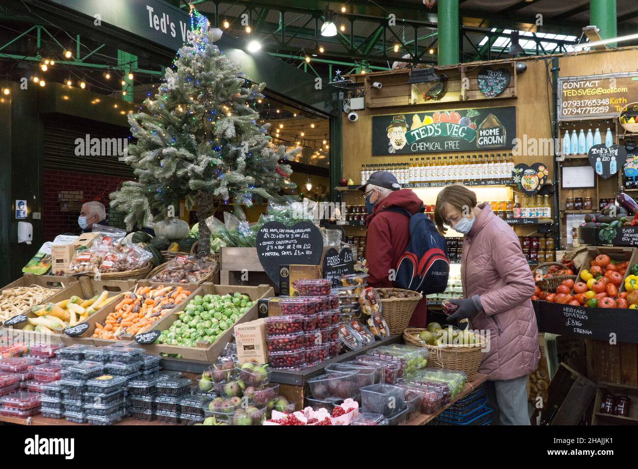 London, Großbritannien, 13. Dezember 2021: Der Borough Market ist ein Open-Air-Markt, der maskenfreies Einkaufen ermöglicht, obwohl einige Leute ihre Masken immer anhaben, da sie in anderen Geschäften und in öffentlichen Verkehrsmitteln obligatorisch sind. Angesichts eines Rückgangs der Zahl der Pendler um etwa 20 %, da die Anordnung der Regierung, wo immer möglich von zu Hause aus zu arbeiten, begann, werden Lebensmittelstände, die auf die Mittagszeit von Büromitarbeitern angewiesen sind, wahrscheinlich einen Einkommensverlust erleiden. Auch der Touristenverkehr ist geringer als sonst. Anna Watson/Alamy Live News Stockfoto