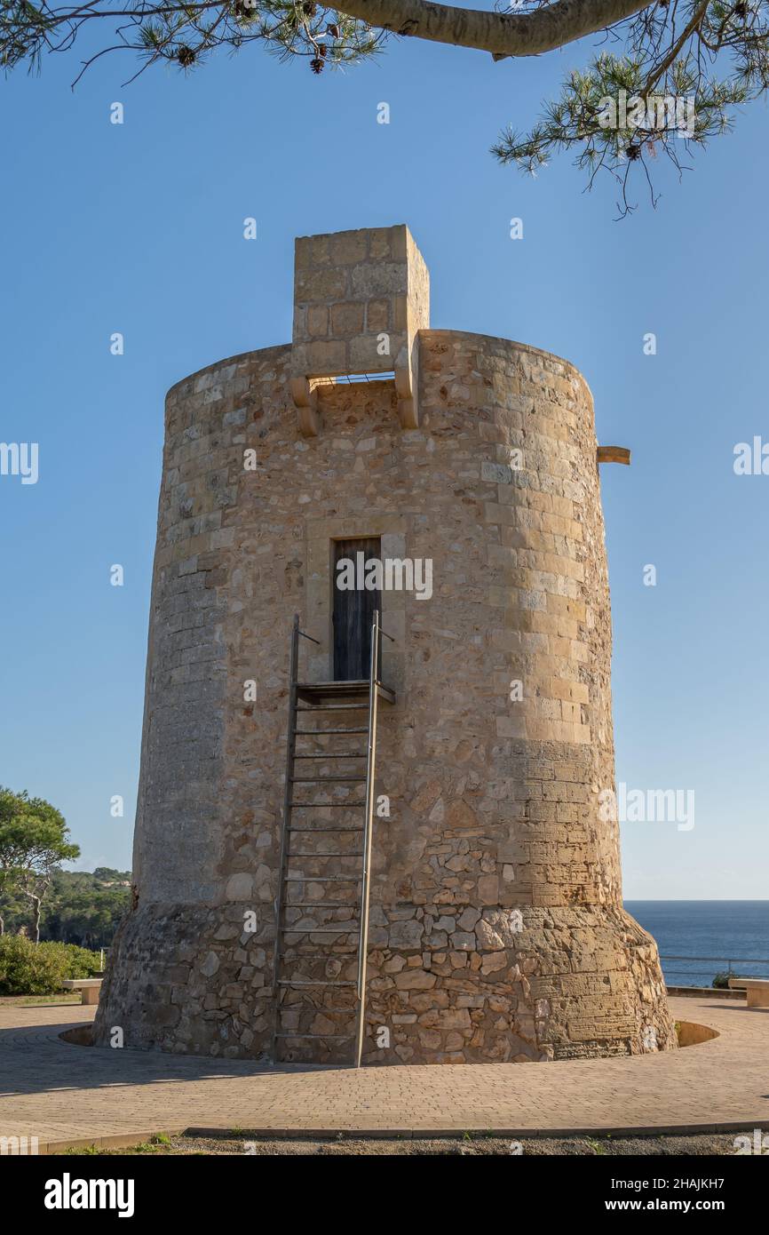 Gesamtansicht des mittelalterlichen Turms Torre Nova im mallorquinischen Ferienort Cala Santanyi, an einem sonnigen Tag mit dem Mittelmeer im Hintergrund Stockfoto