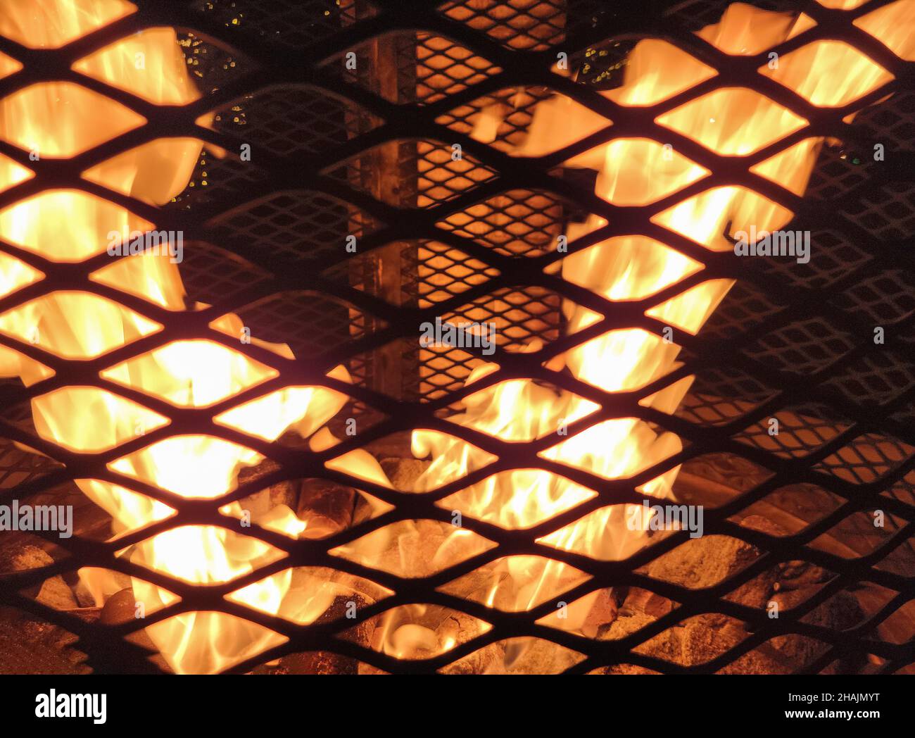 Nahaufnahme der Flammen in der Feuerstelle mit schwarzem Gitter Stockfoto