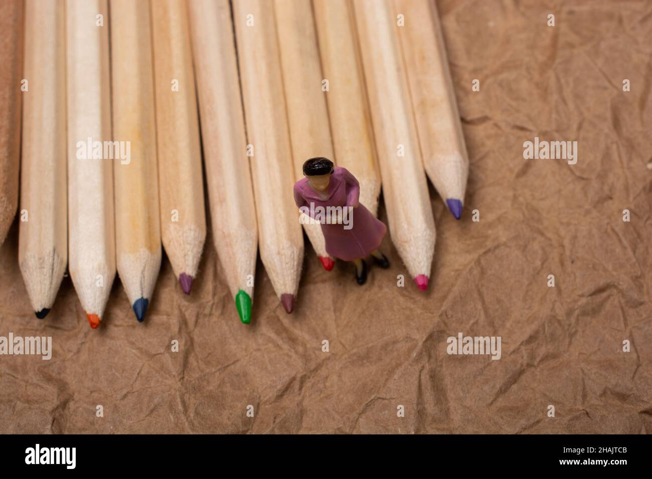 Buntstifte auf Papierhintergrund mit einer Frauenfigur Stockfoto