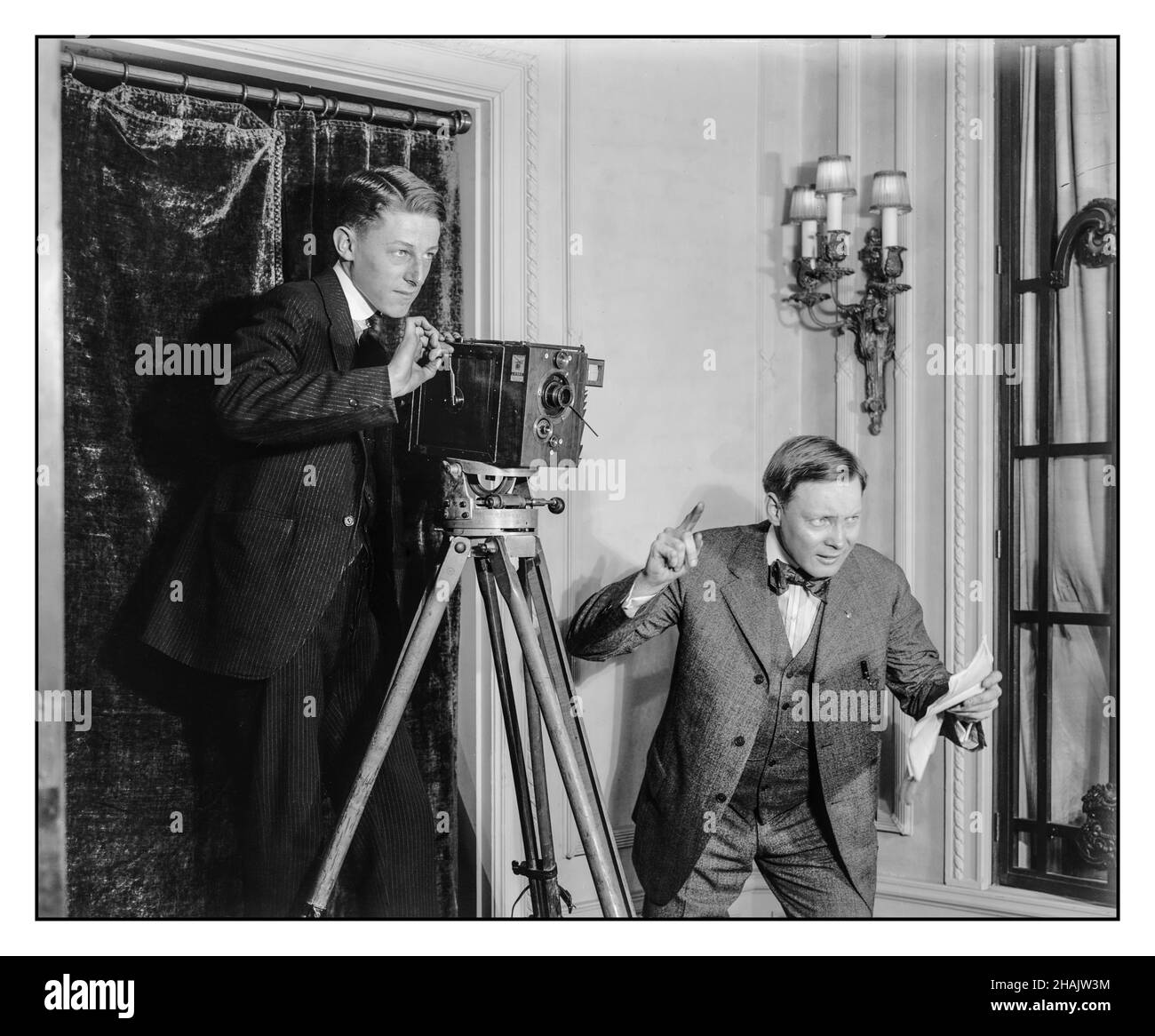 1900er Early Cinematography Vintage Movie Making. Zwei Männer kurbeln mit einer 35mm-mm-Hand die stumme Filmkamera auf einem Stativ im Innenbereich. Regisseur mit Drehbuch der „Action“ Detroit Publishing Co. USA Amerika [Zwischen 1908 und 1920] Filmfotografie 'Le Parvo' /'J. Debrie, Paris' auf Herstellerschild auf 35-mm-Filmkamera. Stockfoto