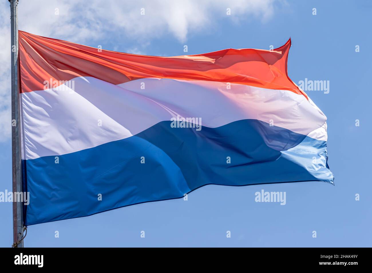 Niederländische Nationalflagge winkt auf blauem Himmel Hintergrund. Königreich der Niederlande, NL Stockfoto