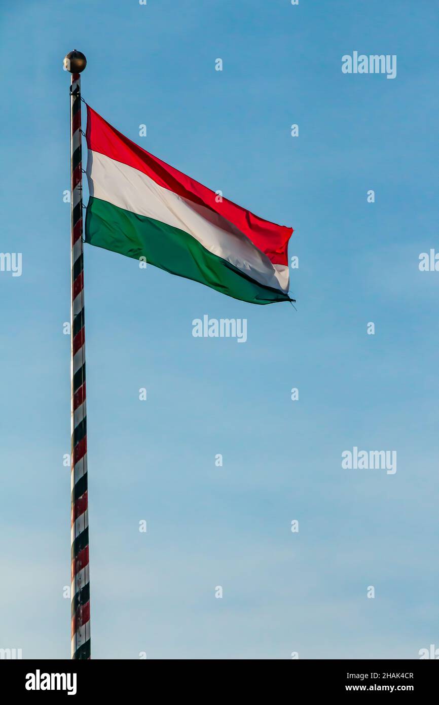 Ungarn, ungarische nationale Flagge schwenkten auf blauen Himmel Hintergrund Stockfoto