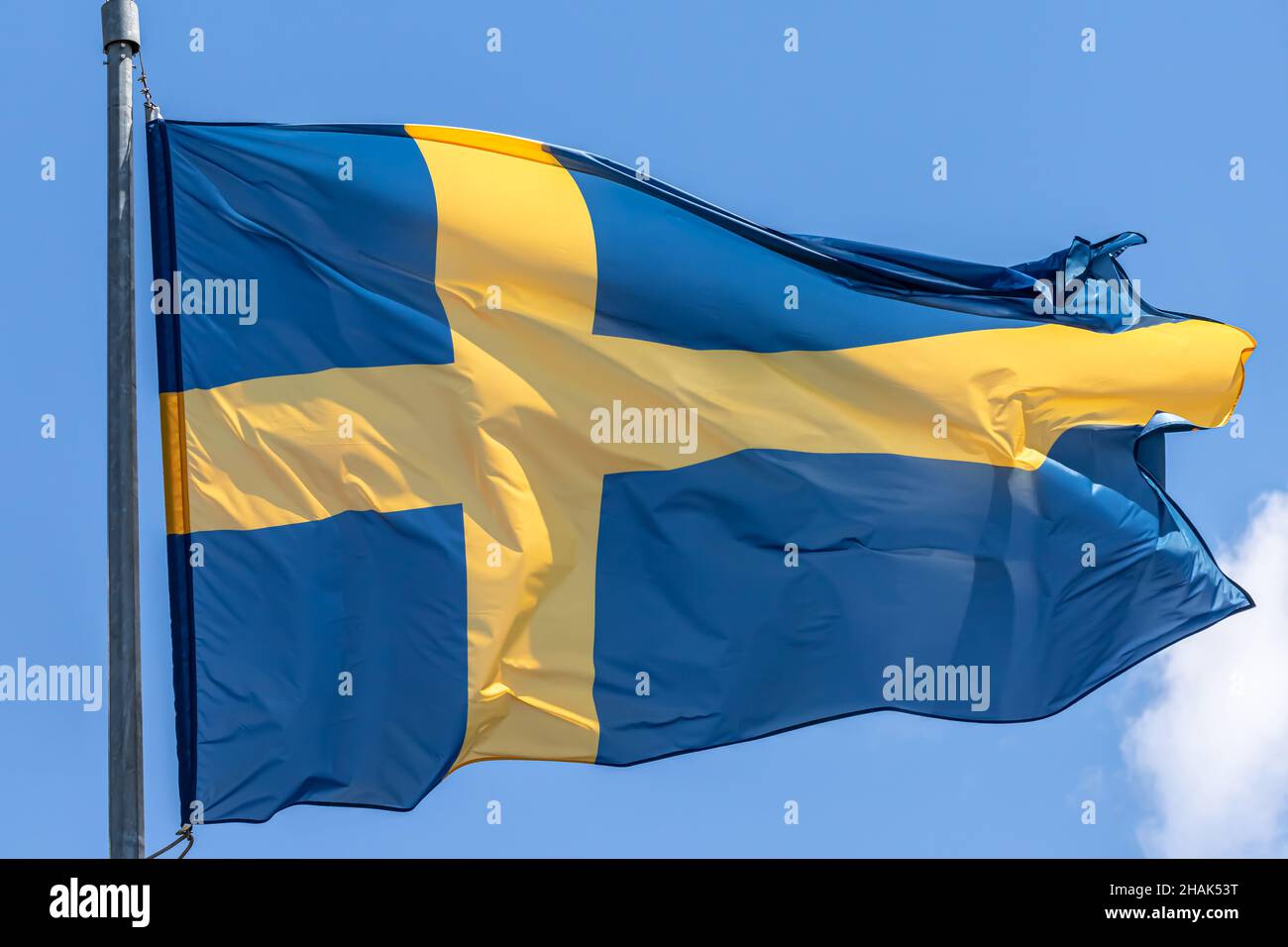 Schwedische Nationalflagge winkt auf blauem Himmel Hintergrund. Königreich Schweden, SE Stockfoto