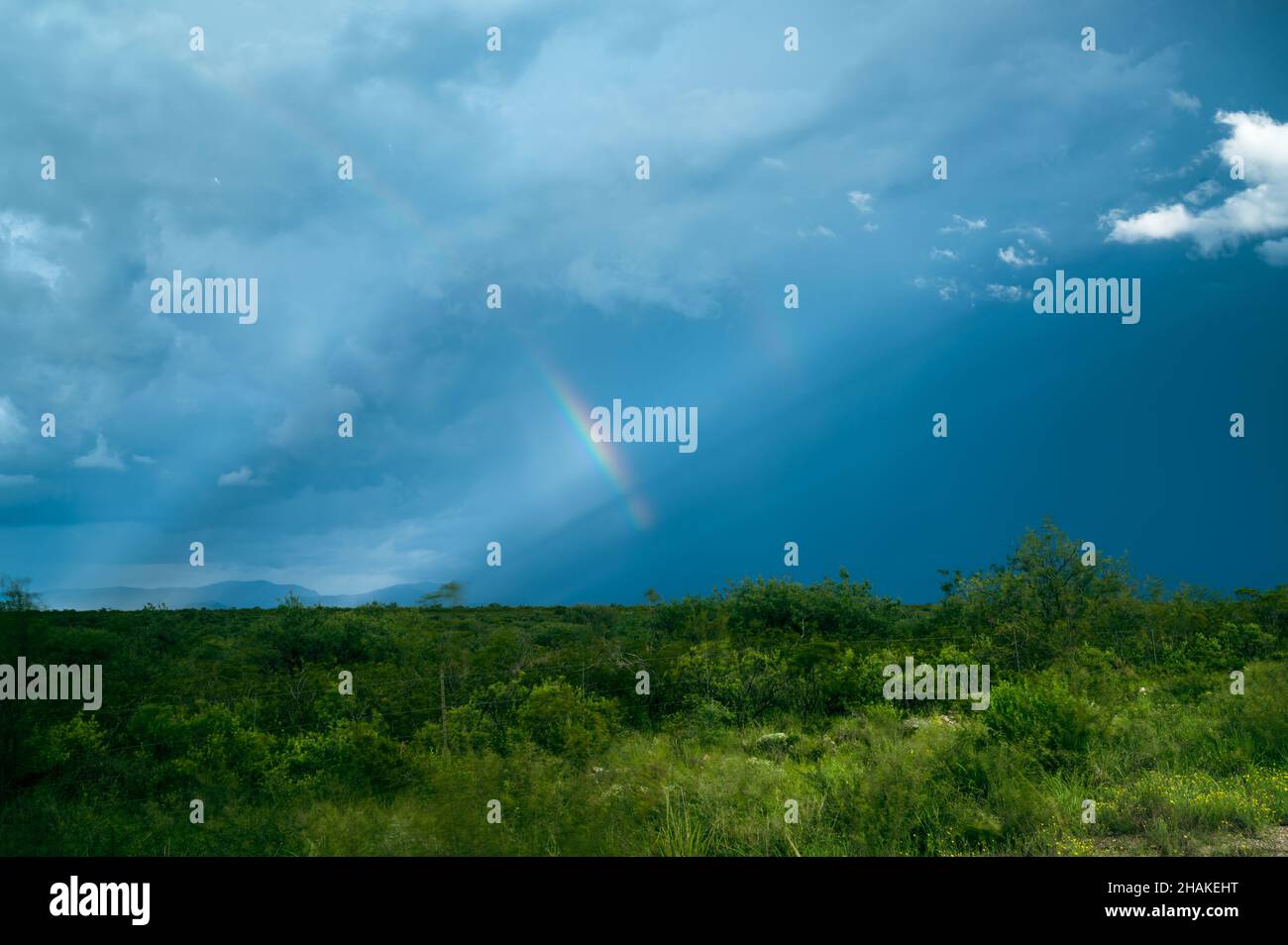 Regenbogen dramatischer stürmischer Himmel in blauen und grünen Farben Stockfoto
