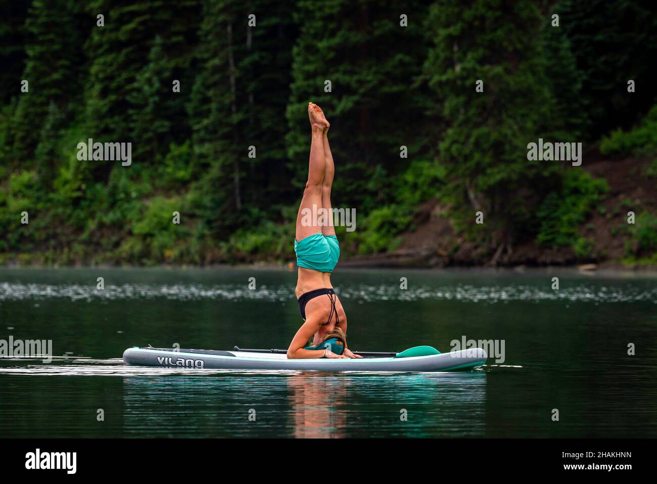 7/14/21 - Crested Butte, Colorado - Eine Frau zeigt, wie man Handstände und Yoga auf einem Paddle Board macht. Stockfoto