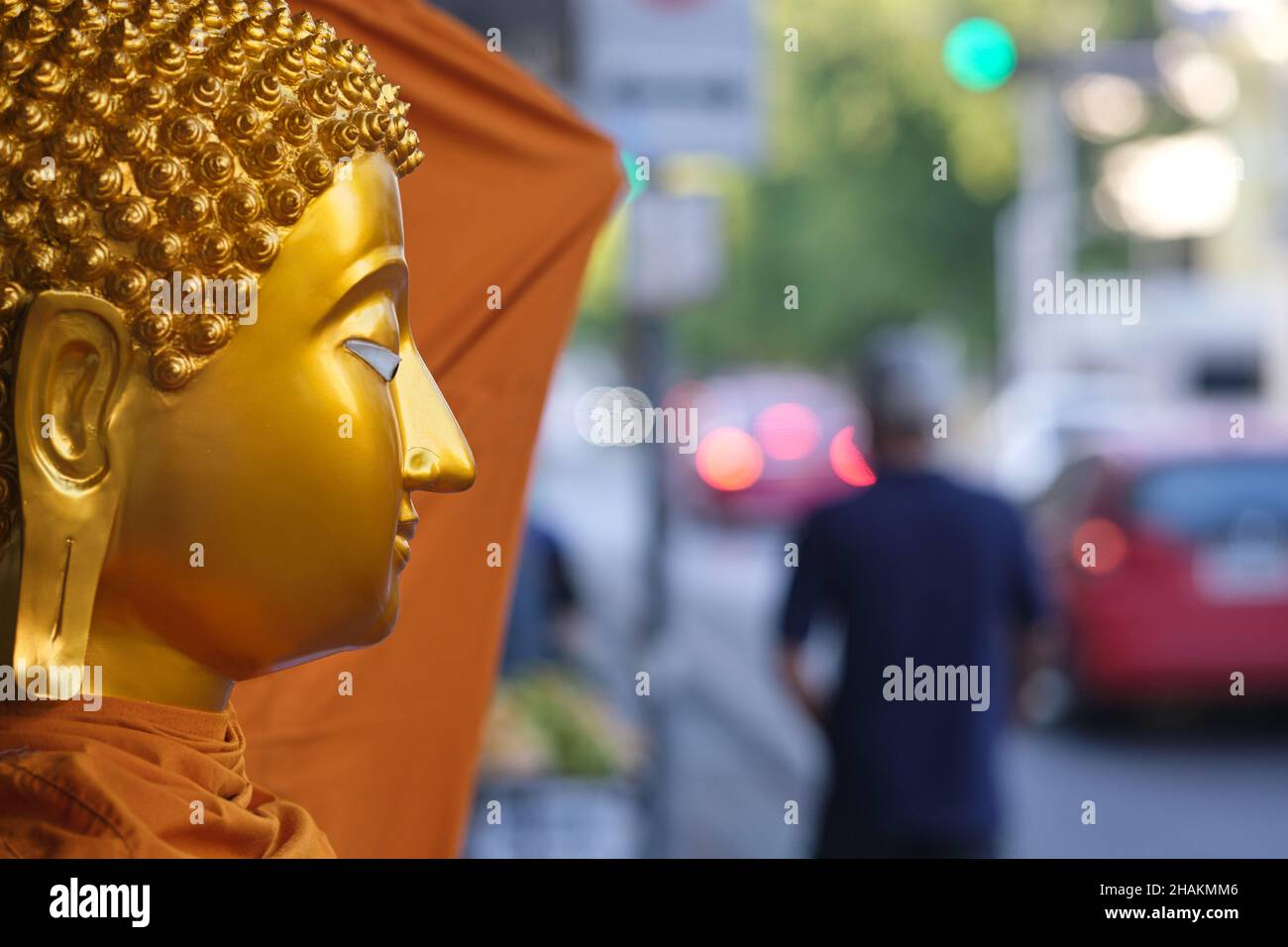 Ein Buddha vor einem Geschäft für buddhistische Gegenstände in der Bamrung Muang Road, Bangkok, Thailand, scheint einen Passanten anzustarren Stockfoto