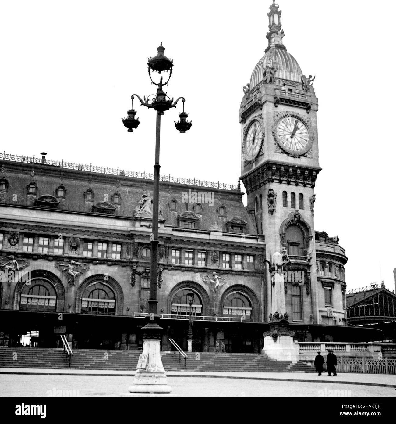 Paris Gare de Lyon, 1945 in der Nähe des Endes des Zweiten Weltkriegs. Ein Blick auf die Vorderseite des Bahnhofs mit seinem berühmten Uhrenturm vom Place Louis Armand. Der Bahnhof wirkt menschenleer, ohne Fahrzeuge und nur drei Fußgänger in Sicht. Stockfoto