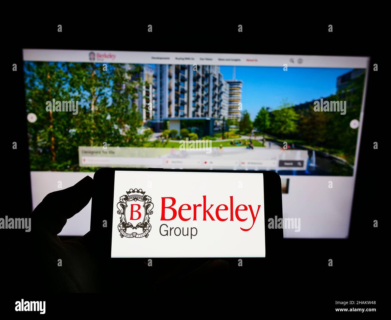 Person, die ein Smartphone mit dem Logo des britischen Unternehmens The Berkeley Group Holdings plc auf dem Bildschirm vor der Website hält. Konzentrieren Sie sich auf die Telefonanzeige. Stockfoto