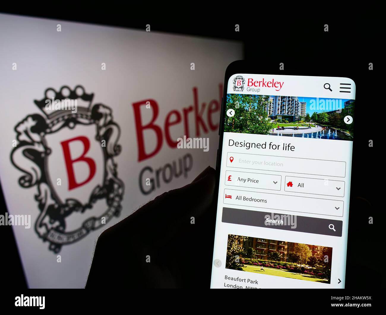 Person mit Mobiltelefon auf der Website des britischen Unternehmens The Berkeley Group Holdings plc auf dem Bildschirm mit Logo. Konzentrieren Sie sich auf die Mitte des Telefondisplays. Stockfoto