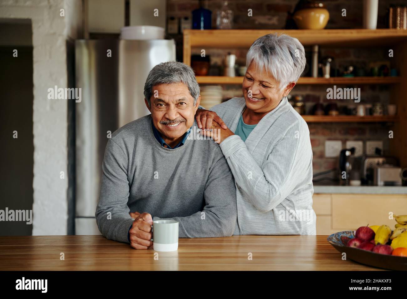 Porträt eines lächelnden älteren Birazialpaares, das in seinem modernen Zuhause den Ruhestand genießt. Drinnen, gesunder Lebensstil. Stockfoto