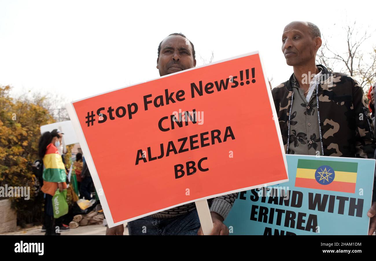 Jerusalem, Israel. 13h Dez 2021. Ein Protestor hält ein Plakat mit der Aufschrift „Stop Fake News! CNN ALJAZEERA BBC' während eines Protestes von äthiopischen Juden und Mitgliedern der eritreischen Migrantengemeinschaft gegen die Politik der Vereinigten Staaten gegenüber dem Tigray-Konflikt in Äthiopien vor der US-Botschaft am 13. Dezember 2021 in Jerusalem, Israel. Kredit: Eddie Gerald/Alamy Live Nachrichten Stockfoto