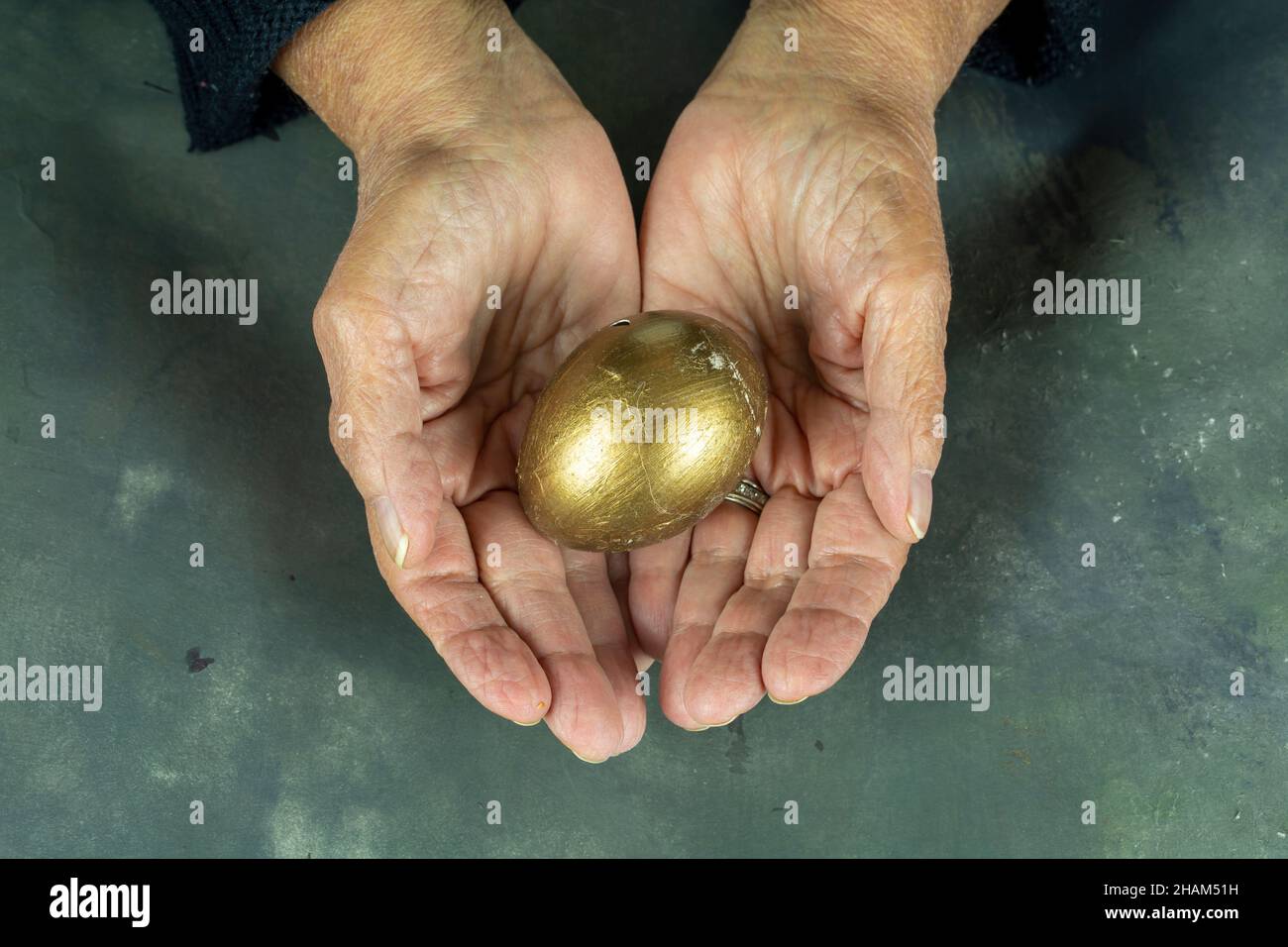 Hände halten modern bemaltes osterei Stockfoto