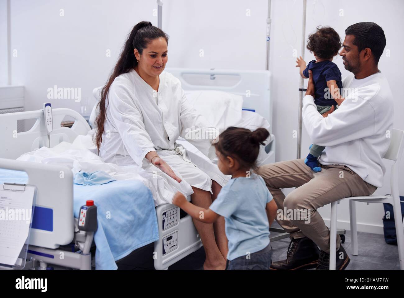 Eltern mit Kindern im Krankenhauszimmer Stockfoto