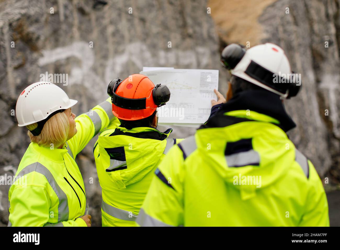 Ingenieure in reflektierender Kleidung diskutieren Pläne Stockfoto