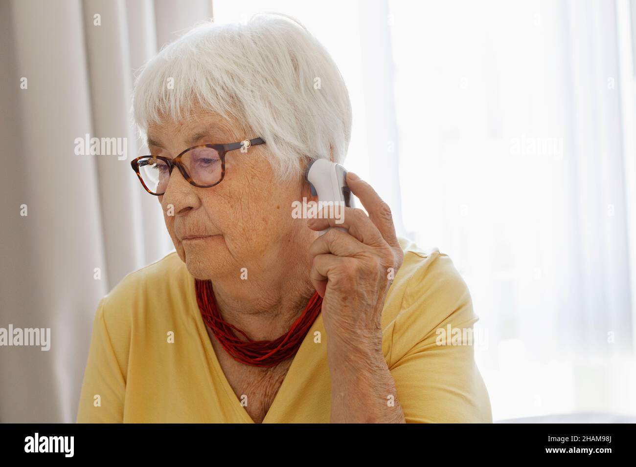 Ältere Frau überprüft die Temperatur Stockfoto