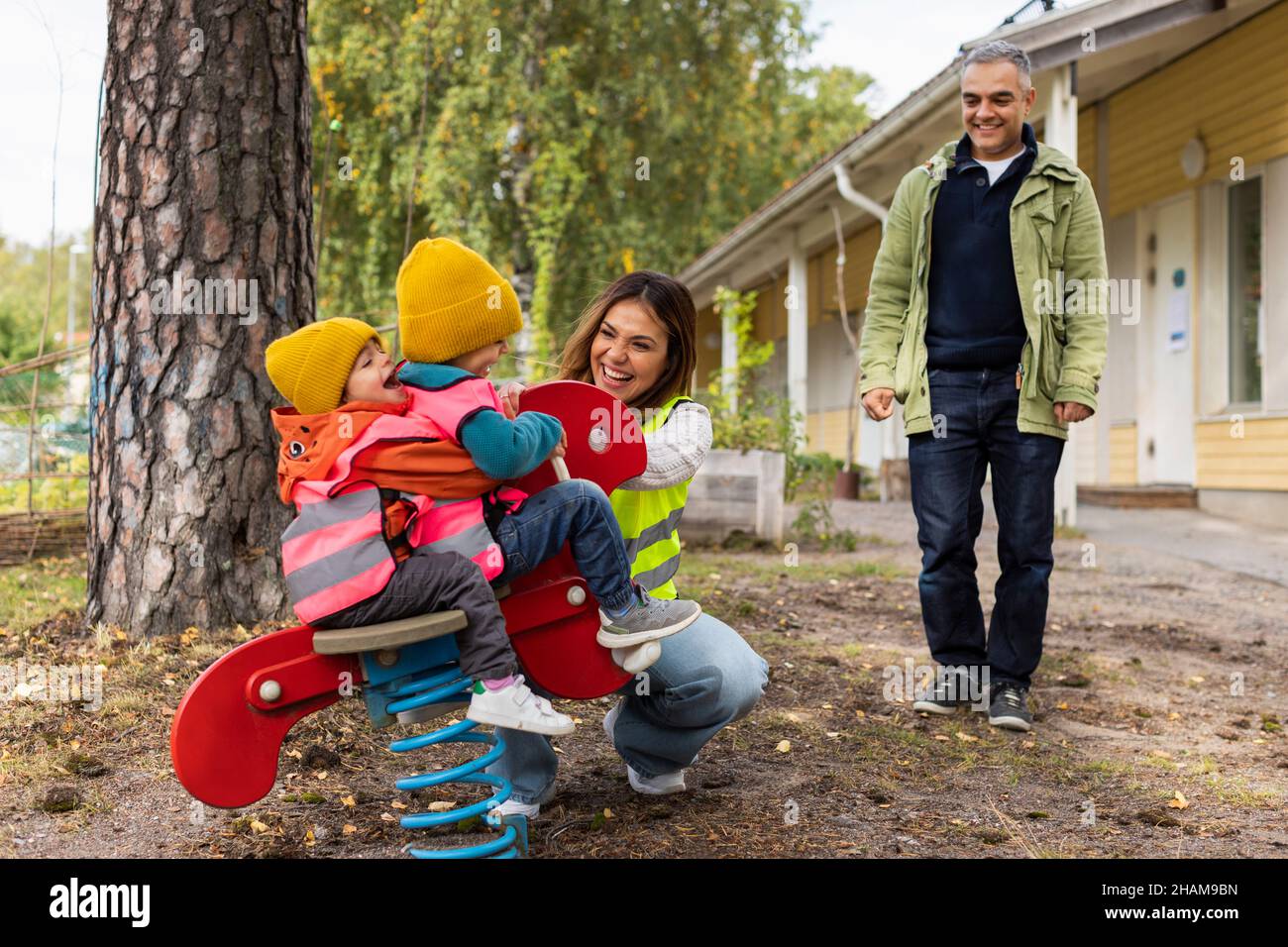 Vorschullehrer und Elternteil mit Schülern auf dem Spielplatz Stockfoto