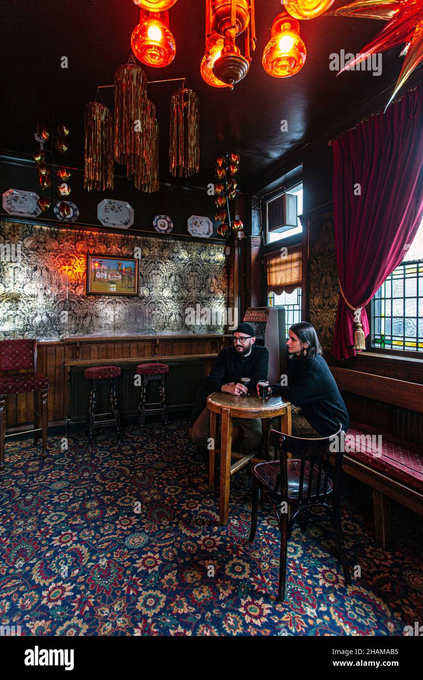 Junges Paar, das im Palm Tree Pub, Mile End, London, England, Großbritannien, trinkt Stockfoto