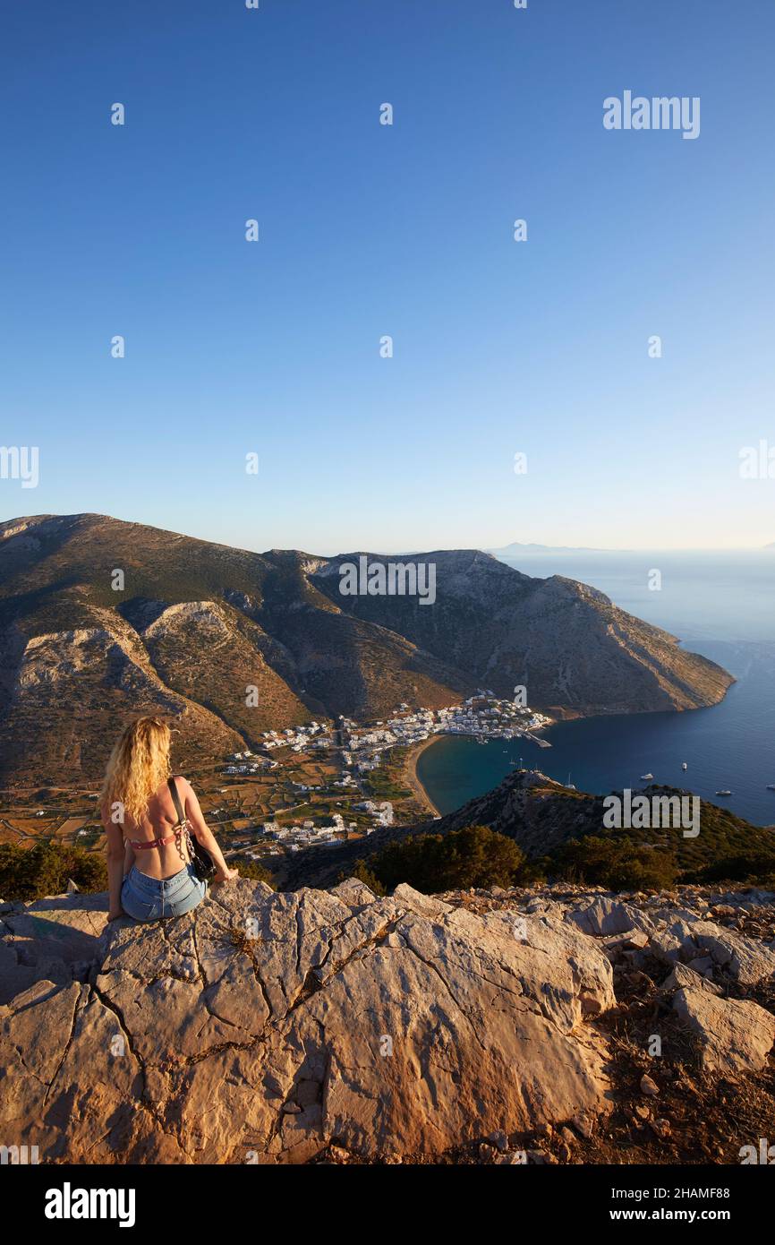 Junge Frau, die das Panorama über die Bucht von Kamares, Sifnos, die Kykladen-Inseln, Griechenland, beobachtet Stockfoto