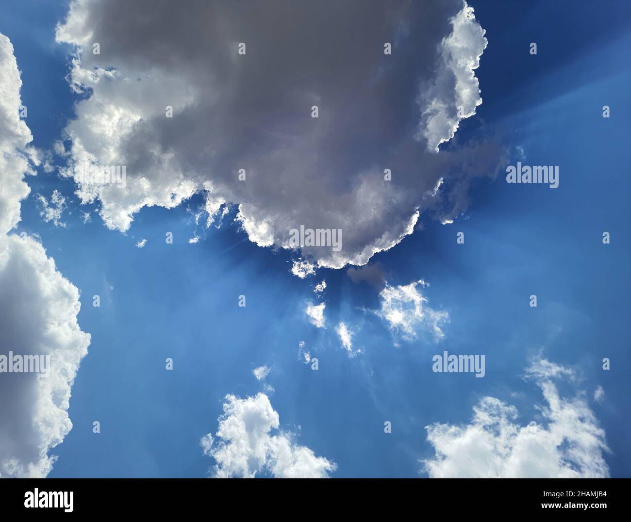 Schöner Himmel und Sonne, die die weißen Wolken erleuchten. Stockfoto
