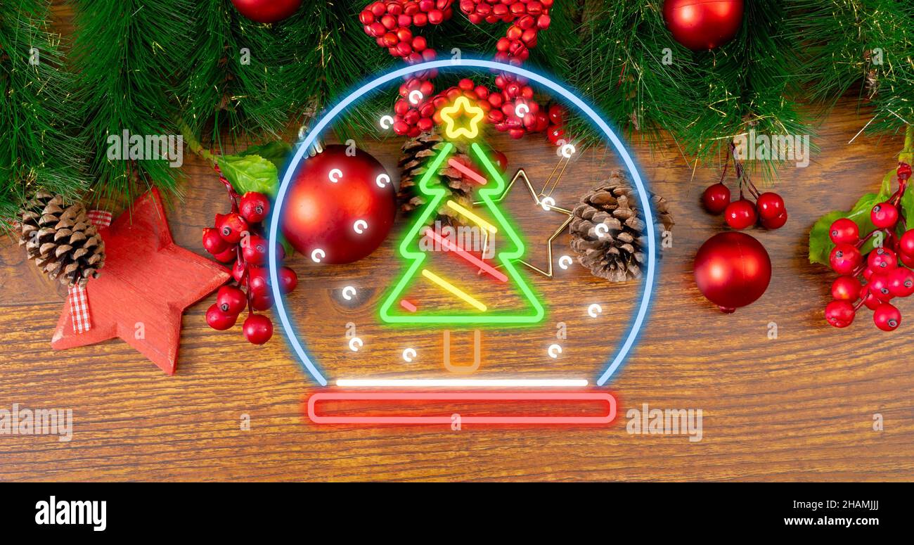 Ansicht von oben auf dem beleuchteten Neon-weihnachtsbaum-Symbol über Dekorationen auf dem Tisch Stockfoto