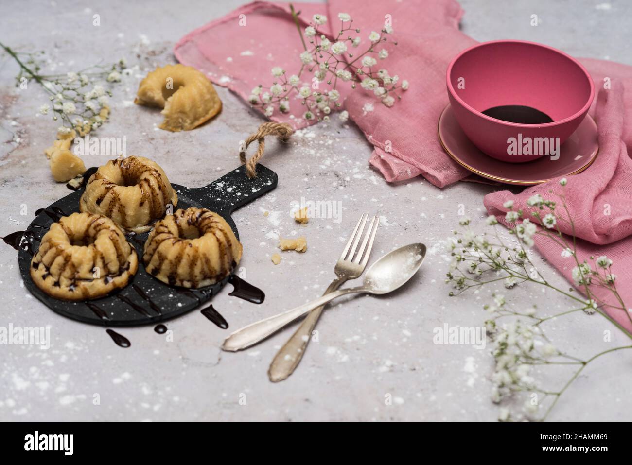 Stillleben mit Kuchen verziert mit Schokolade und Puderzucker auf weißem Hintergrund. Stockfoto