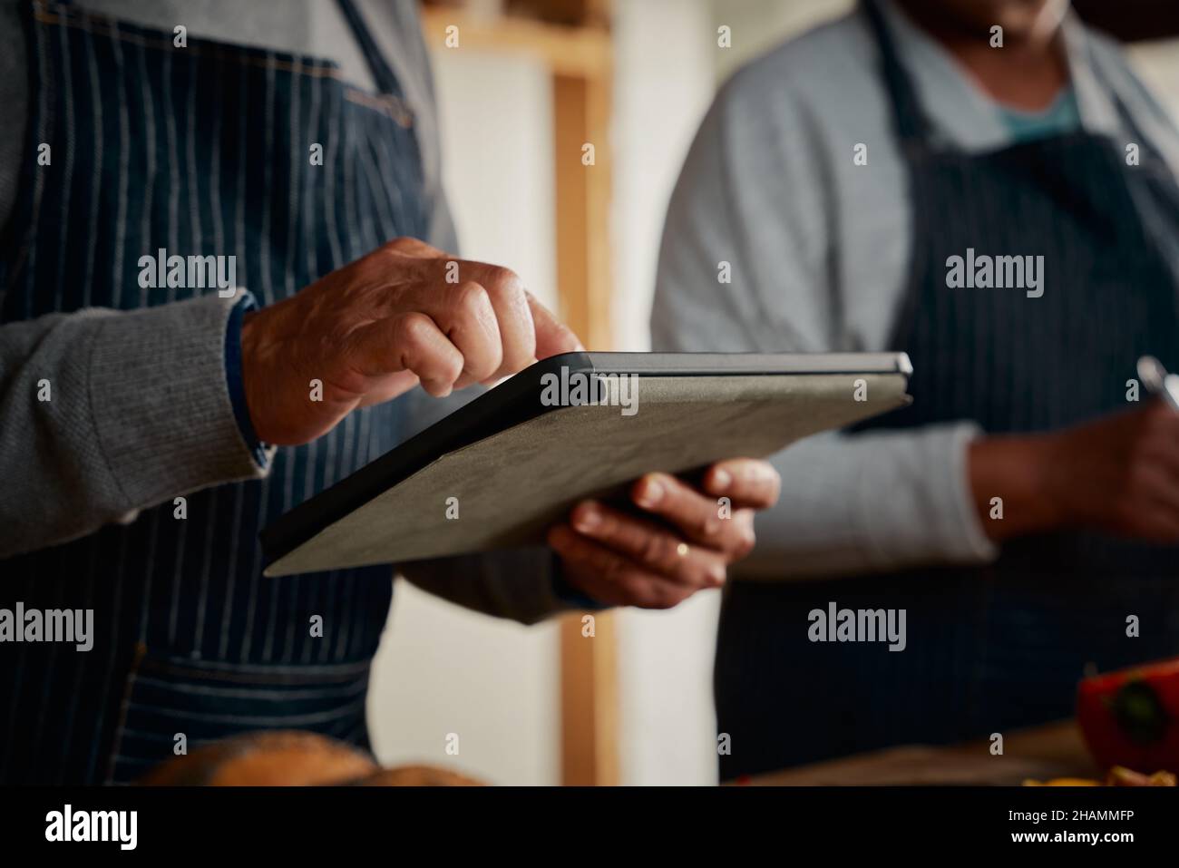 Hände von multikulturellen älteren Männern mit Tablette Rezept in der Küche zu erforschen. Glückliches Paar, das gesunde Mahlzeiten kocht. Stockfoto