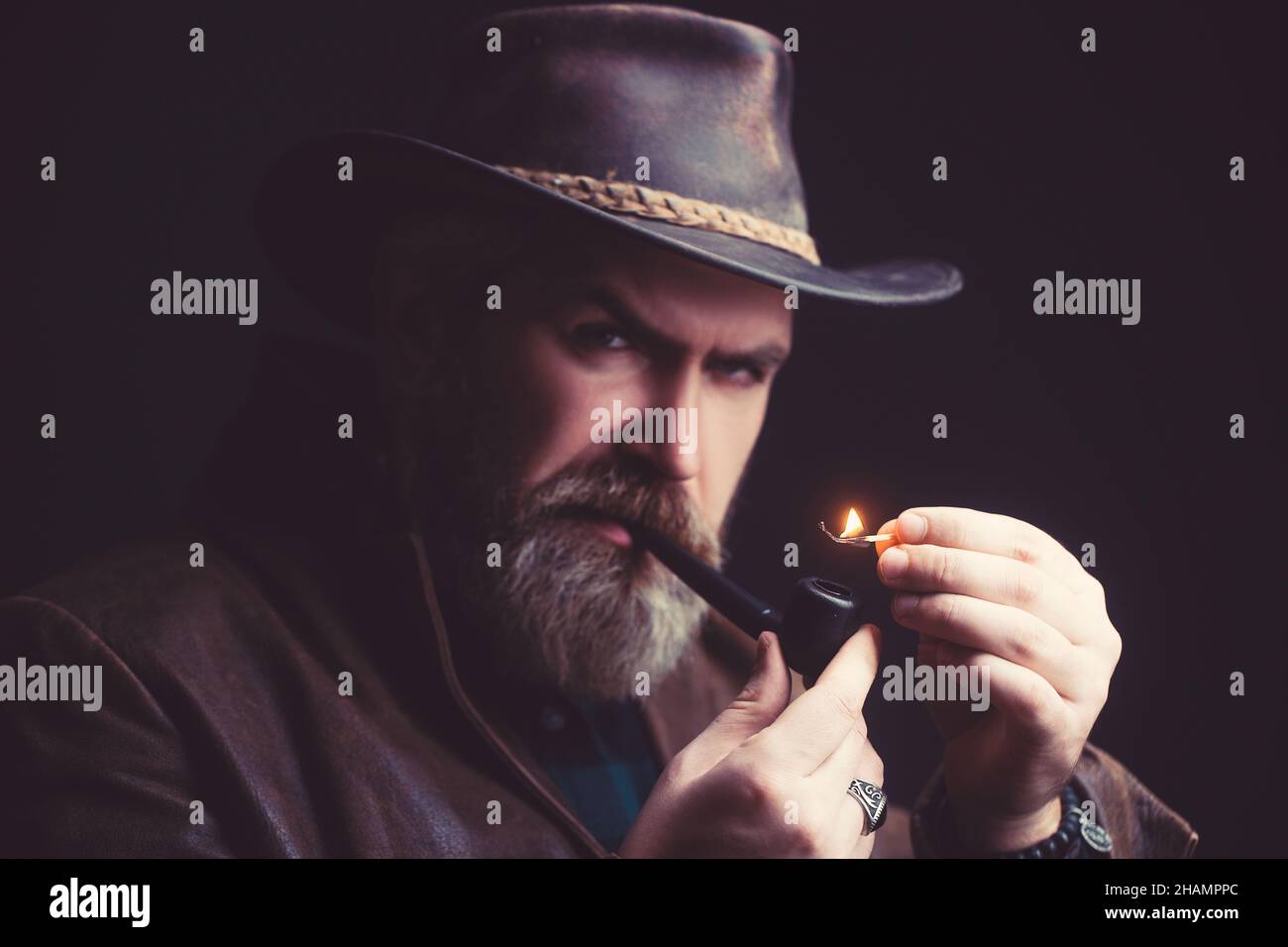 Bärtiger Mann, der traditionelle Pfeife raucht. Modisches Porträt. Stockfoto
