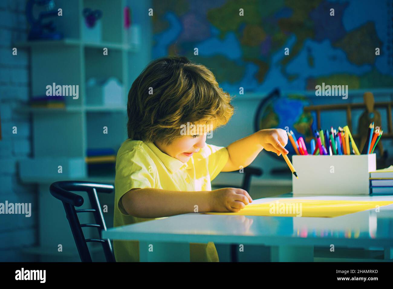 Porträt eines niedlichen Jungen Lernen im Klassenzimmer auf dem Tisch. Stockfoto