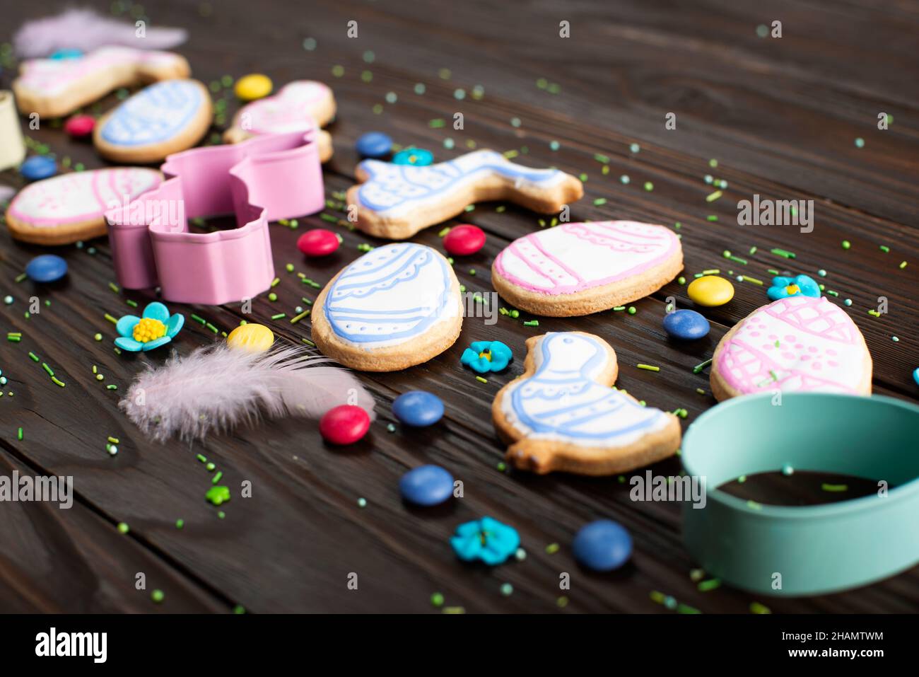 Plätzchen schneiden Federn und Ostergartuschen in Form von Ei, Huhn und Kaninchen auf dunklem Holzhintergrund. Platz für Text. Stockfoto