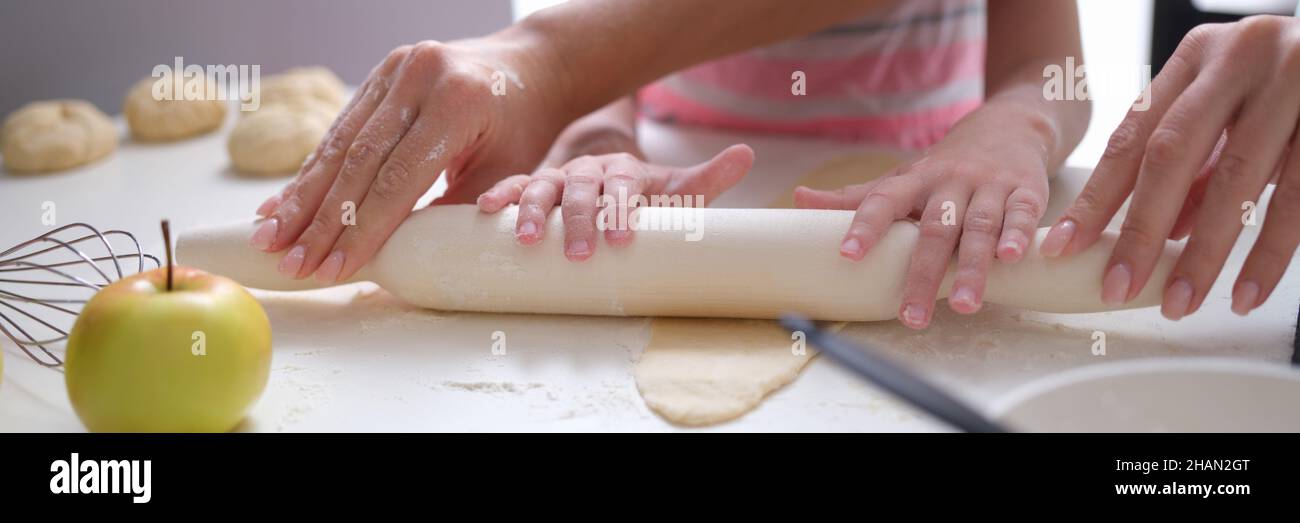 Mama und Tochter Rollen in der Küche Teig mit Nudelholz aus Stockfoto