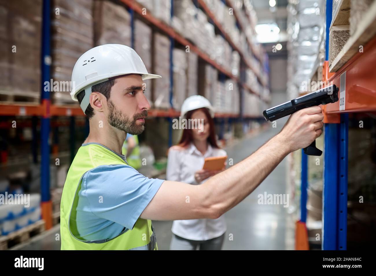 Mann scannt Barcode von Fracht und Frau mit Tablet Stockfoto