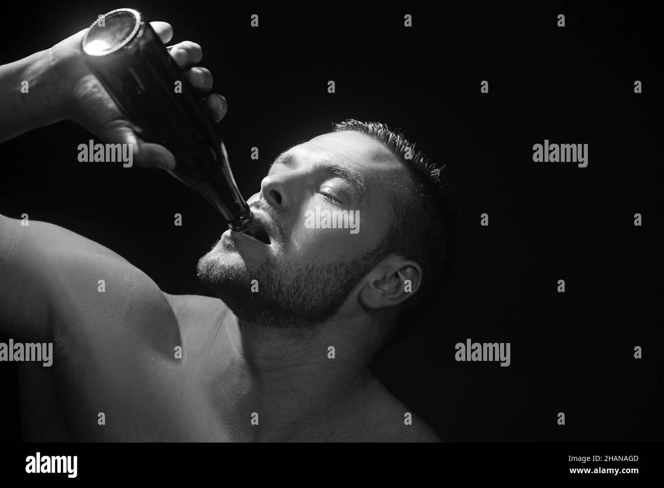 Nahaufnahme eines starken Mannes, der eine Flasche Bier trinkt. Stockfoto