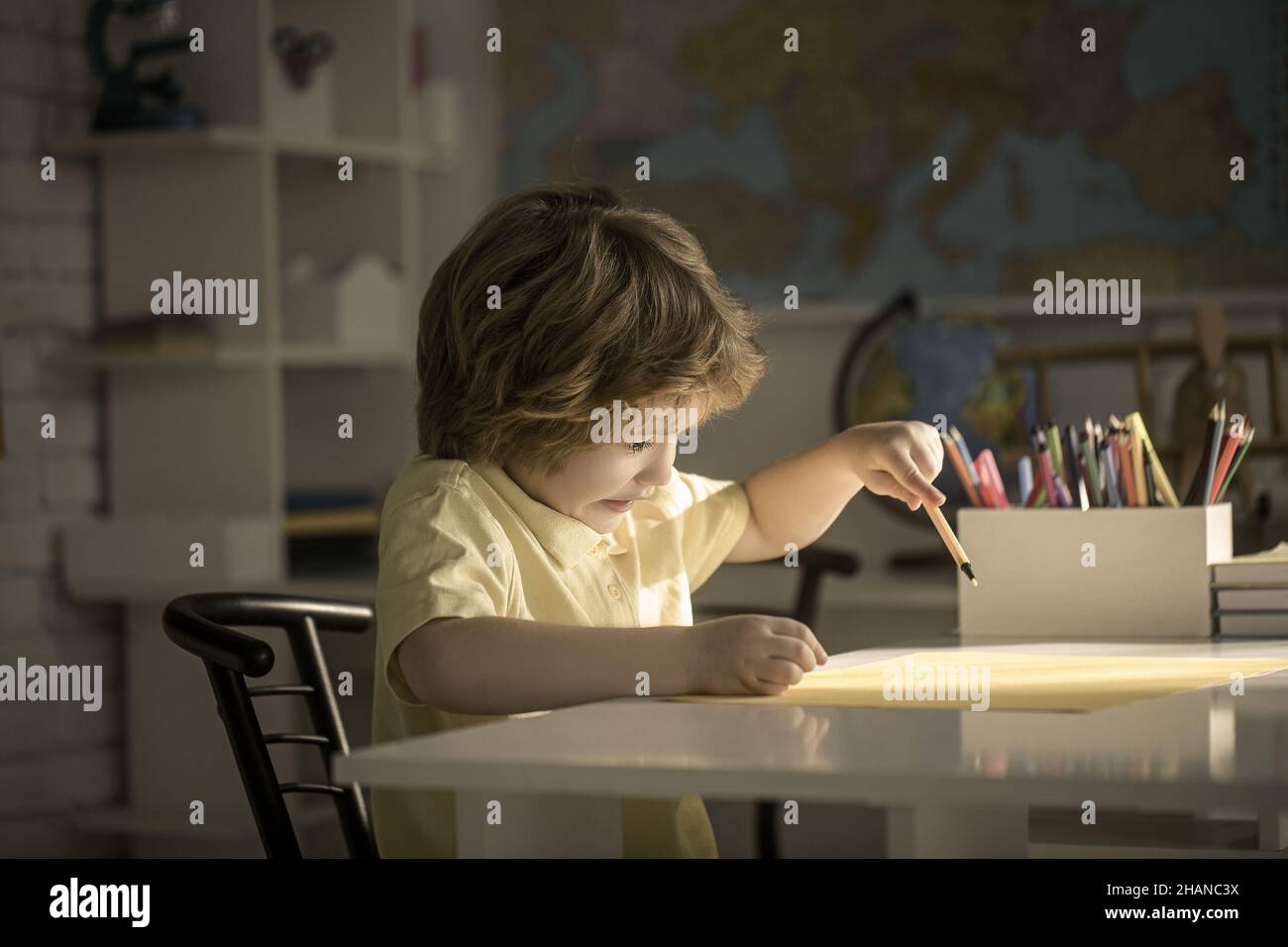 Porträt eines niedlichen Jungen Lernen im Klassenzimmer auf dem Tisch. Stockfoto