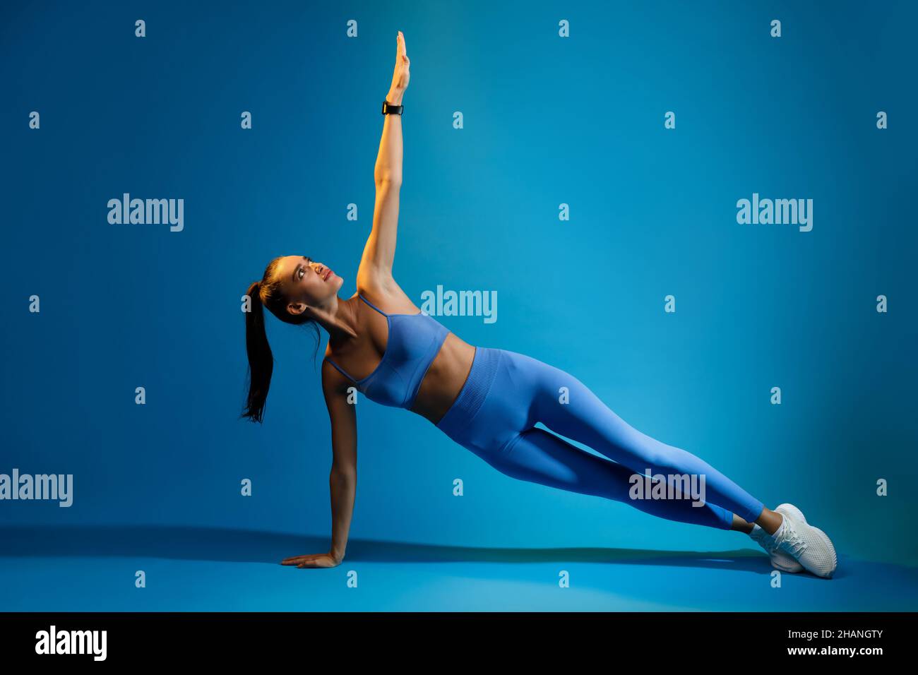 Sportliche Dame Macht Side Plank Übung Auf Blauem Hintergrund Stockfoto