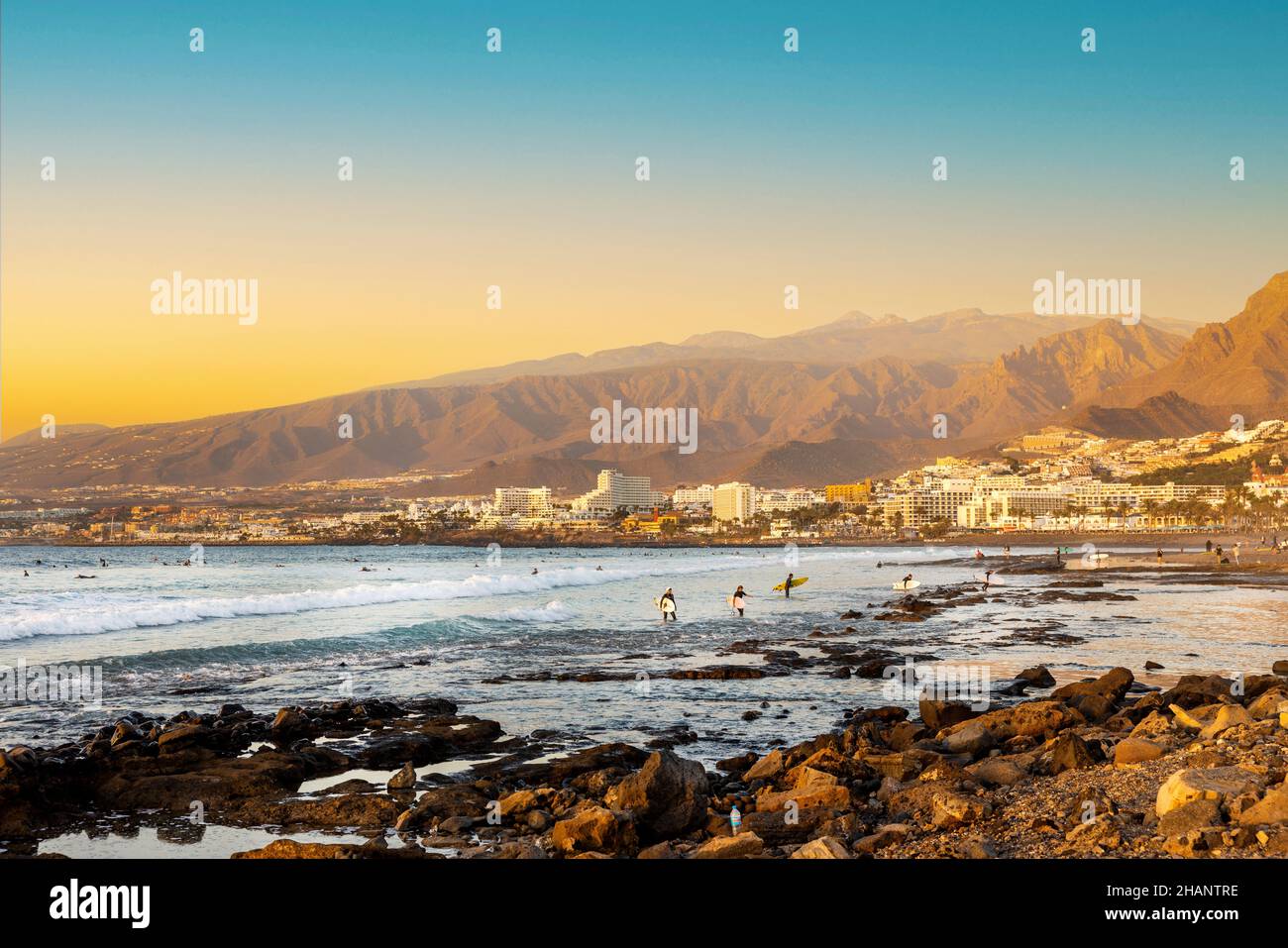Playa de las Americas. Surfer am Strand auf Teneriffa bei Sonnenuntergang Stockfoto