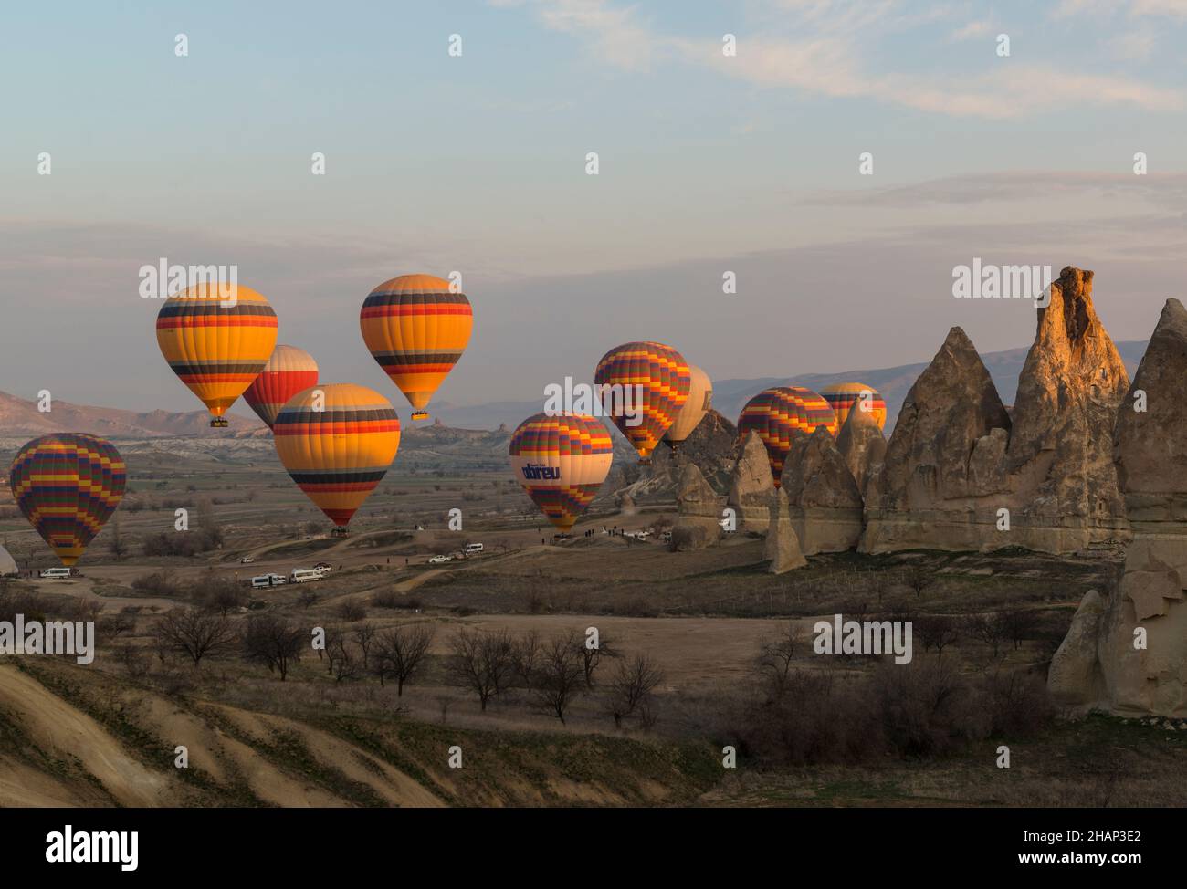 Dutzende von Heißluftballons mit Hunderten von Touristen, die am frühen Morgen in der Nähe von Goreme, Kappadokien, Zentralanatolien, Türkei, abheben Stockfoto