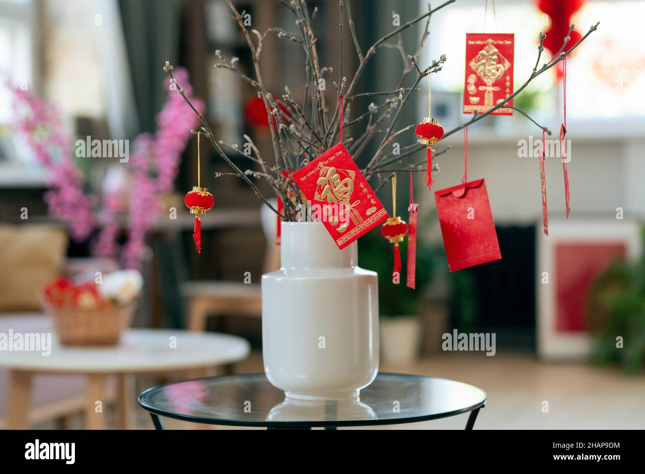 Weiße Vase mit Ästen und handgefertigten Postkarten, die ein glückliches chinesisches Neujahr sagen Stockfoto