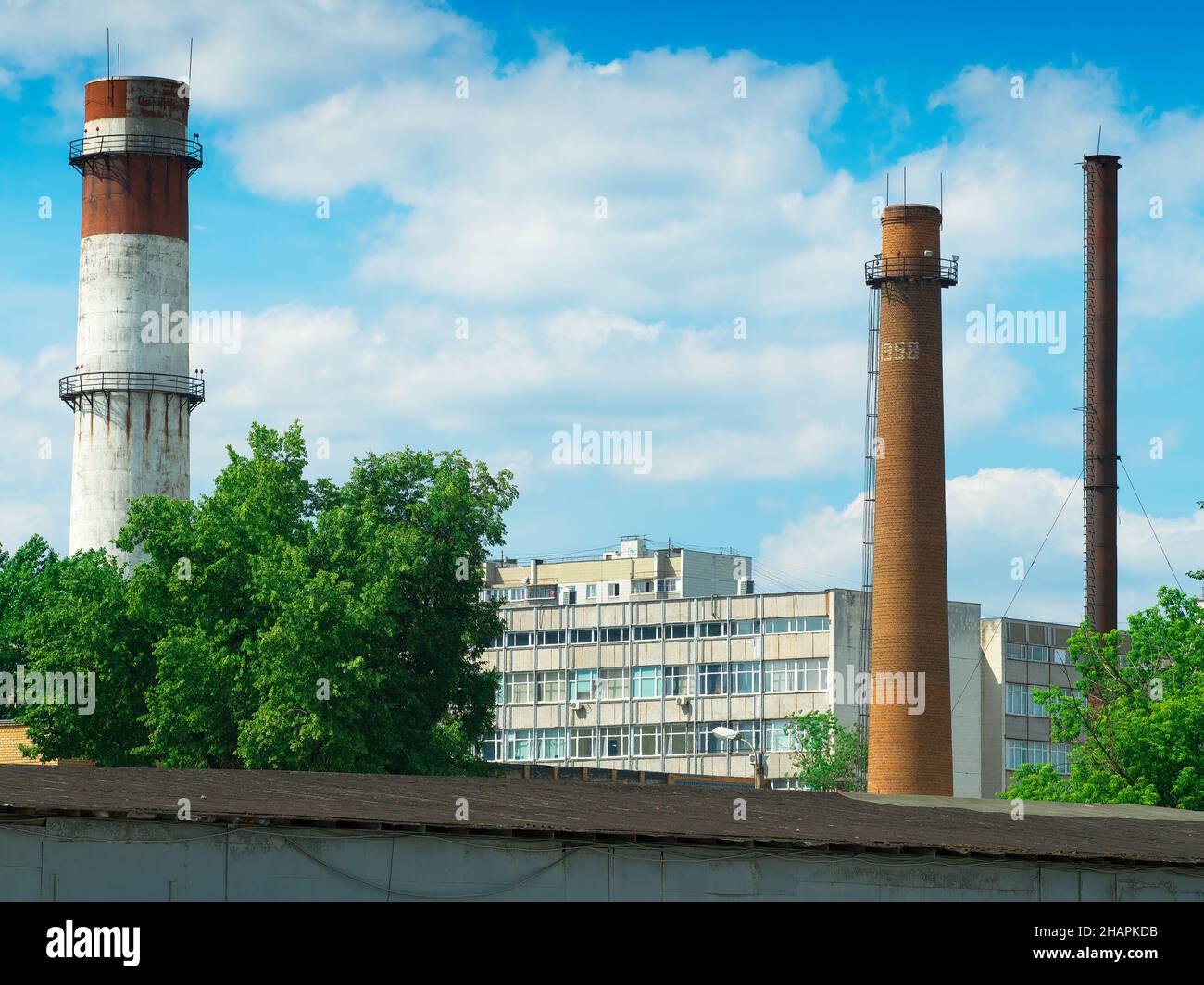 Industriekamine im Hintergrund der russischen Fabrik Stockfoto