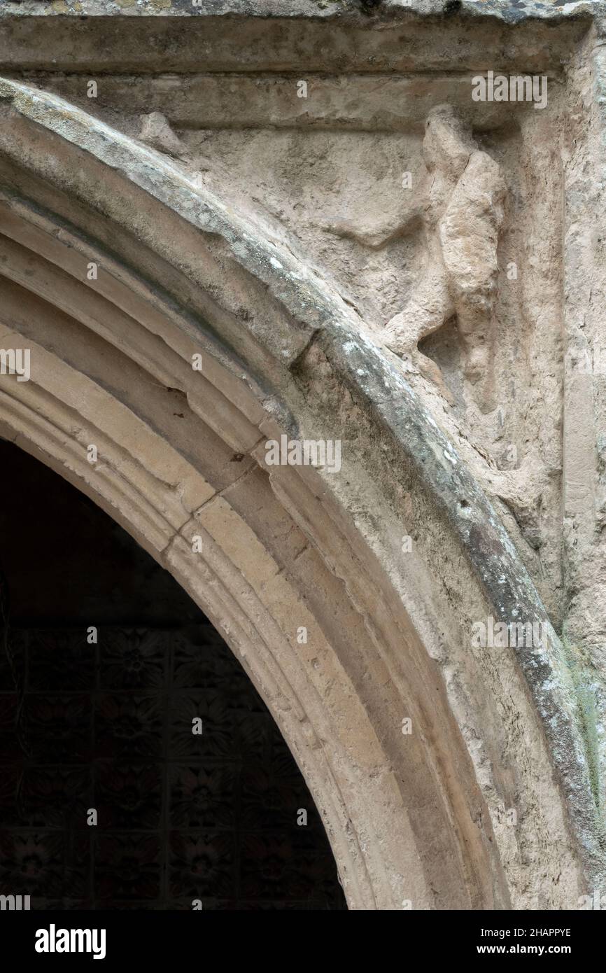 Eine Holzfigur, die in den vorderen Steinbogen der Kirche St. Mary of the Assumption, Ufford, Suffolk, Großbritannien, geschnitzt wurde Stockfoto