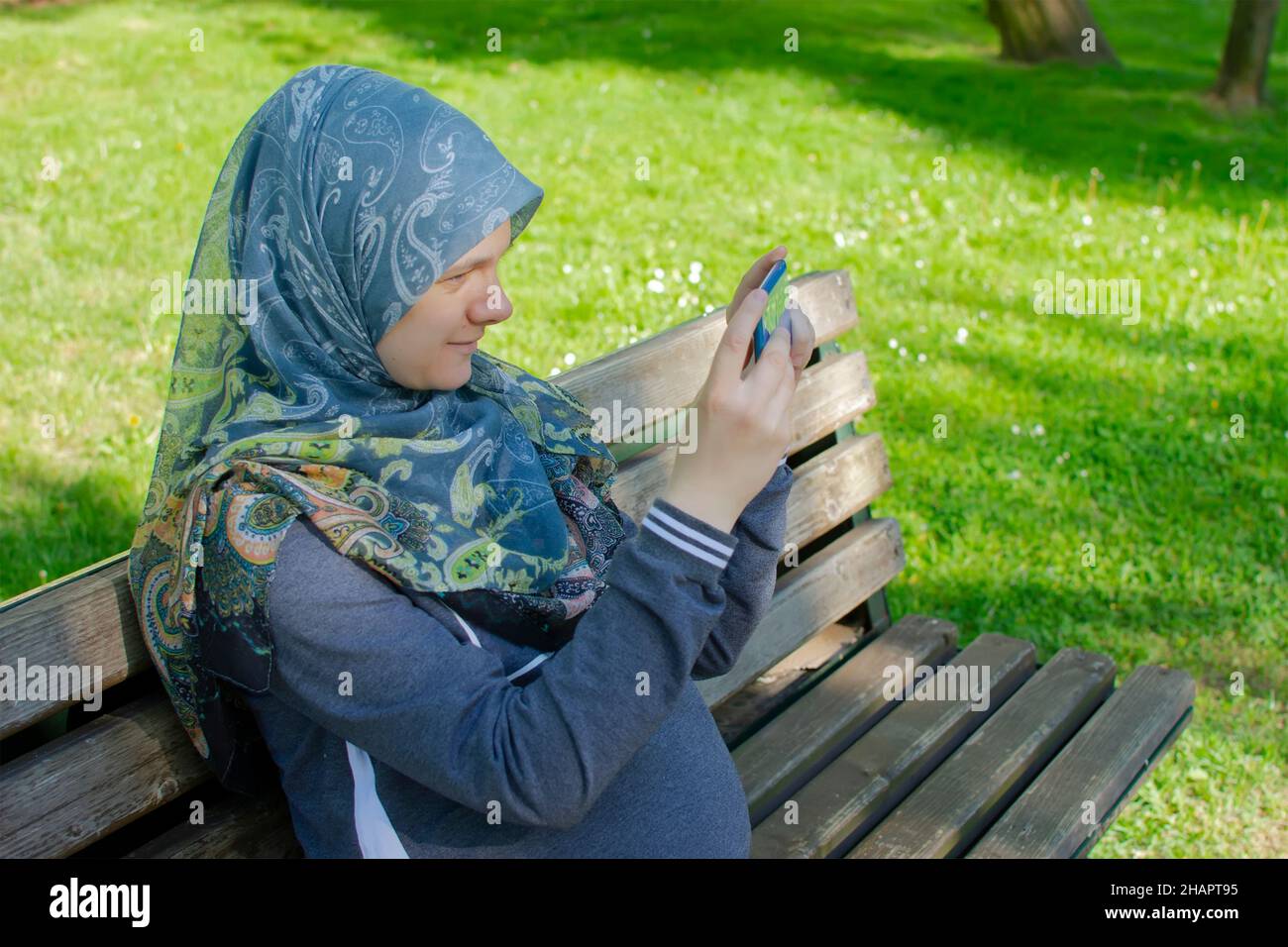 Schwangere muslimische Frau, die Naturlandschaft Foto mit dem Smartphone Stockfoto
