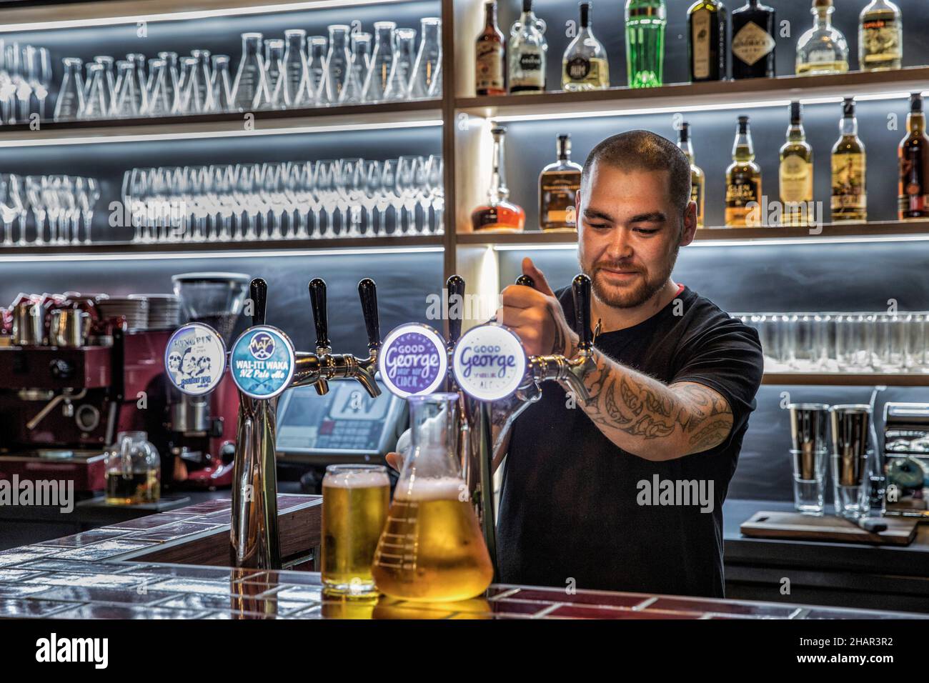 Ein Barkeeper zieht in einer Bar ein Pint Bier. Stockfoto