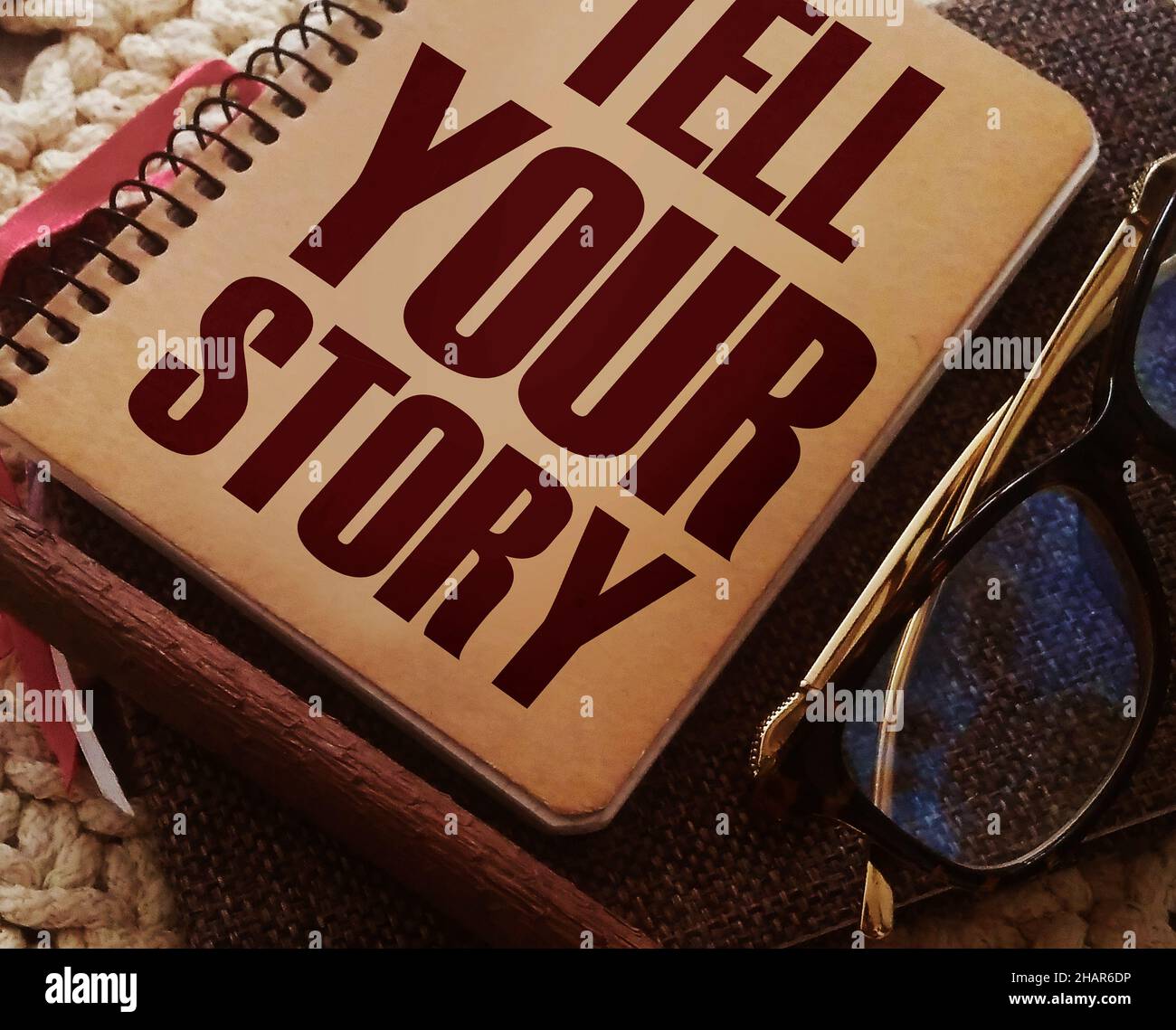 Text Erzählen Sie Ihre Geschichte auf dem Cover von Buch, Brille und Stift. Geschäftskonzept für Storytelling Telling Story auf Notizblock Titelseite geschrieben. Stockfoto