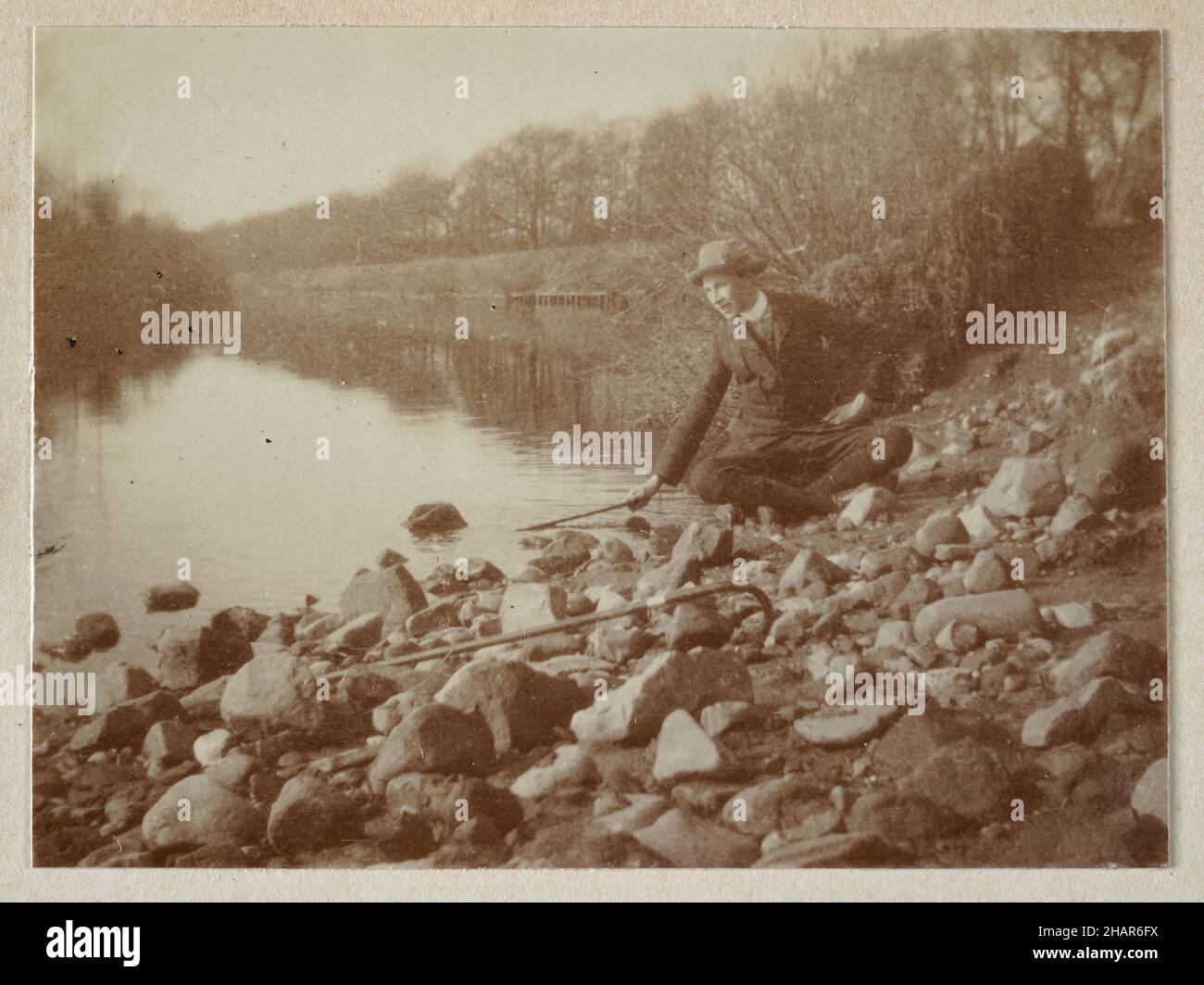 Vintage-Foto eines jungen Mannes, der am Ufer eines Flusses saß, Wandern, Landschaft, Edwardian England 1905 Stockfoto