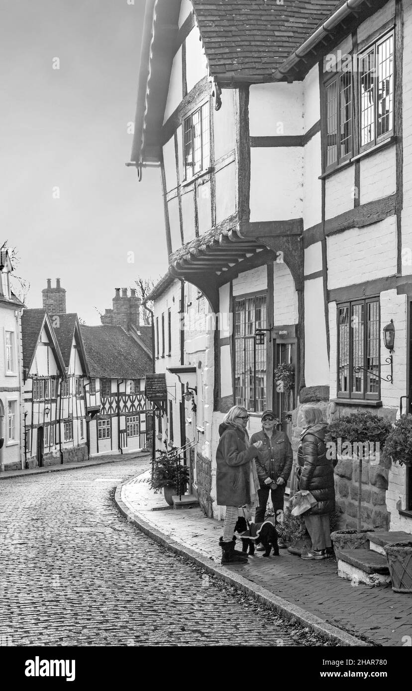 Schwarz-weiße Fachwerkhütten entlang der gepflasterten Mill Street in der Marktstadt Warwickshire, Warwick Stockfoto