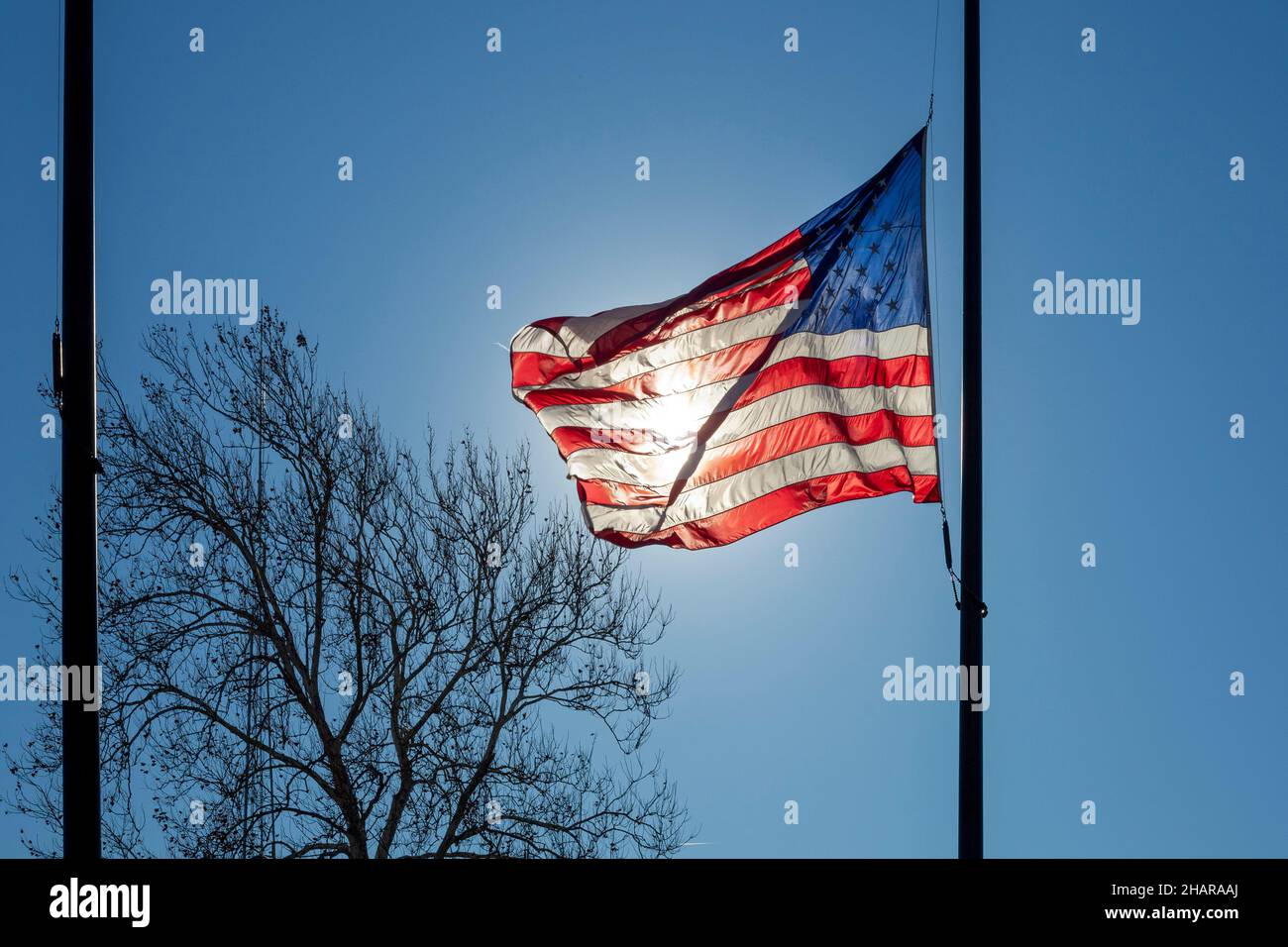 Detroit, Michigan - die Sonne scheint durch eine amerikanische Flagge, die am Detroit Historical Museum fliegt. Stockfoto